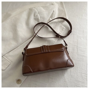 Detailed view of vintage brown leather shoulder bag with white contrast stitching and strap