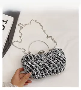 Detail of luxury rhinestone evening bag with silver metal handle and wavy crystal pattern