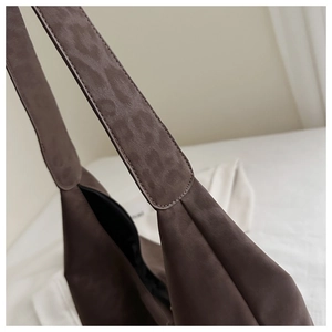 Detail of coffee tote bag featuring leopard embossed strap and matte texture finish