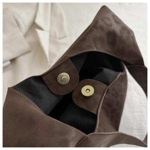 Detail of the magnetic snap closure and black lining on the leopard print tote bag