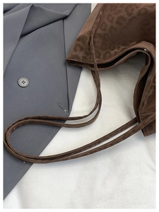 Detailed view of dark brown leopard print shoulder bag with premium animal texture