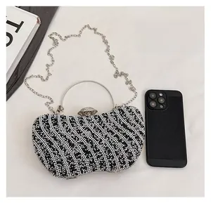 Detailed view of rhinestone evening clutch with crystal wave patterns and metal handle