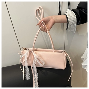 Pink baguette bag with white lace ribbon detail and thin faux leather shoulder strap