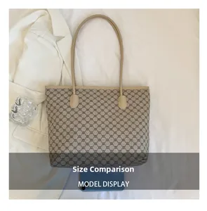 Close-up of a large coffee monogram tote bag showing size comparison with a smartphone