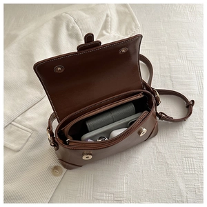 Detail view of the brown vintage crossbody bag interior with a central zipper compartment