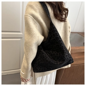 Detail of vintage black leopard print tote bag with soft texture on female shoulder