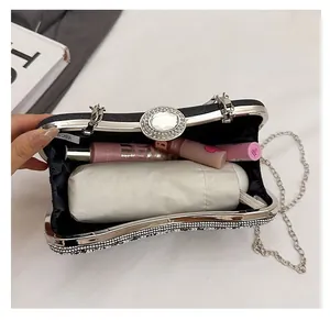 Detailed interior view of a sparkling rhinestone clutch bag holding an umbrella and lip gloss