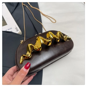 Detail of dark brown leather evening bag with wave gold metal decor and chain