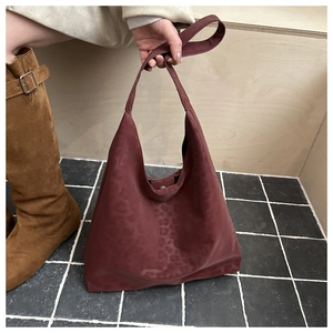 Macro shot of dark red leopard embossed leather texture and magnetic buckle on large tote bag
