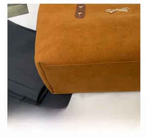 Detail showing precise stitching and golden bow charm on brown matte tote bag