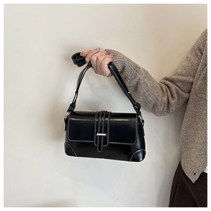 Detail of vintage black patent leather bag with white contrast stitching and metal buckle