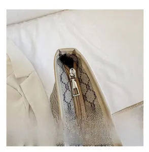 Detail shot of smooth silver metal zipper on large brown tote bag with geometric pattern