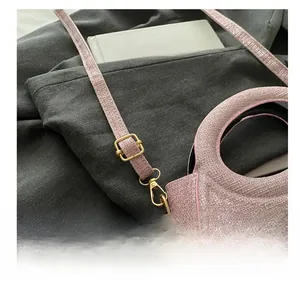 Detail of adjustable golden buckle on pink sequin crossbody bag over grey blazer