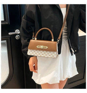 Detail of crossbody bag featuring retro patchwork leather and gold metal buckle lock