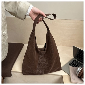 Detail of dark brown leopard print tote bag with suede texture shown in daily commute scene