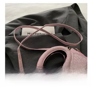 Detailed close-up of pink woven texture handbag with adjustable strap and gold hardware