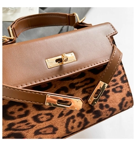 Detail of leopard print flap bag featuring a golden metal twist lock and leather stitching