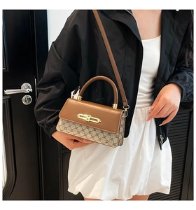 Detail of vintage patchwork crossbody bag with brown leather flap and golden chain buckle