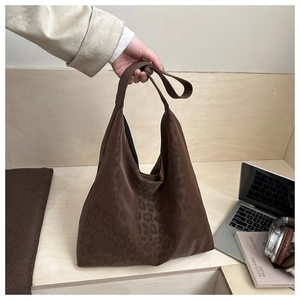 Close-up of brown leopard print texture on a large soft commuter tote shoulder bag