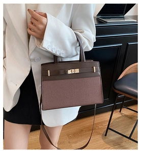 Détail du mélange cuir marron foncé et texture tissée avec fermoir doré rotatif