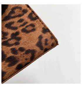 Detailed close-up of leopard print faux fur material with premium stitched edges