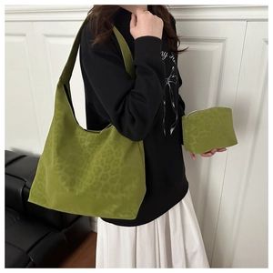 Detail of green leopard print canvas tote bag set with matching zippered pouch on a shoulder