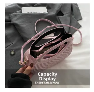 Detail view of the interior compartment and pink textured fabric of the handbag