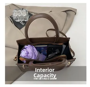 Vue intérieure du sac en cuir marron montrant le compartiment spacieux avec les accessoires