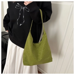 Olive green hobo bag with subtle leopard print shown on model with shoulder strap