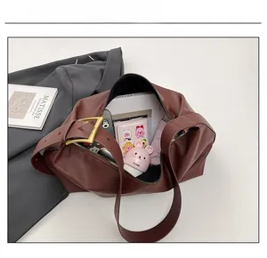Macro shot of brown tote bag interior capacity showing daily essentials and gold buckle