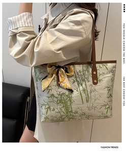 Détail du cabas en toile avec imprimé bambou, anses en cuir et foulard décoratif