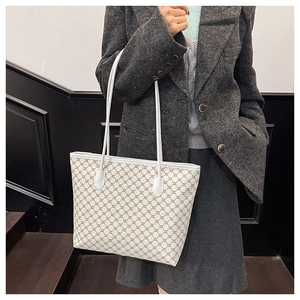 Detail shot of white tote bag with brown geometric patterns and elegant shoulder straps