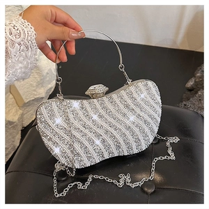 Macro view of sparkly rhinestone wave pattern and pearl beads on luxury silver evening bag