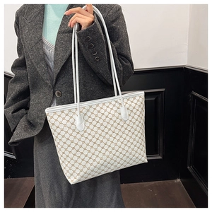 Detail view of large tote bag with brown chain print and white leather handles for women