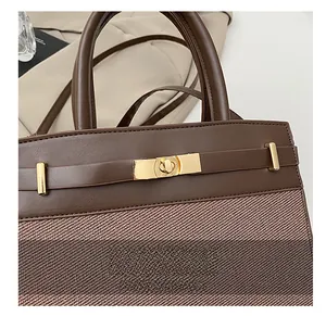 Détail d'un sac à main vintage avec fermoir doré et tissu tissé texturé