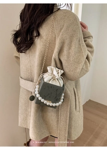 Detailed view of grey marble texture crossbody bag with pearl handle and gold chain