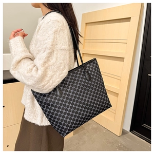Detail of large tote bag with vintage grey geometric pattern and black leather straps