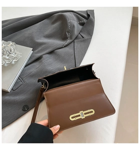 Detail view of brown patchwork crossbody bag interior with gold buckle and flap design