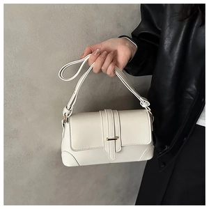 Detail of off-white crossbody bag with gold metal buckle and premium faux leather finish