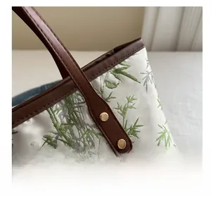 Detail shot of bamboo pattern jacquard fabric with premium leather trim and metal rivets