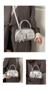 Macro shot of silver metallic bowling bag with pearl bow and heart charm detail