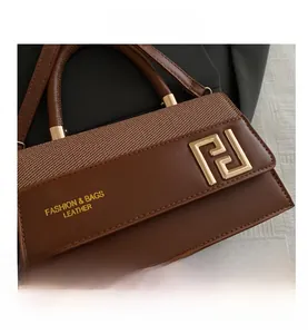 Close-up of brown patchwork handbag featuring woven texture and golden geometric logo