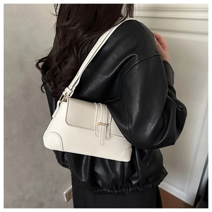 Chic beige underarm bag with gold hardware shown on a model in a black leather jacket