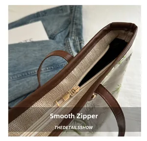 Detail of premium metal zipper and brown textured leather trim on bamboo canvas tote bag