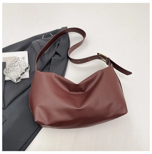 Detail of dark brown minimalist tote bag featuring adjustable wide shoulder strap and matte leather