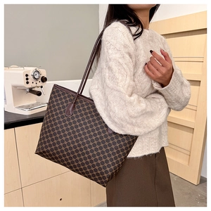 Close-up of vintage printed tote bag with leather strap on model's shoulder