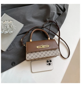Flat lay of a vintage patchwork shoulder bag with leather details on a stylish desk