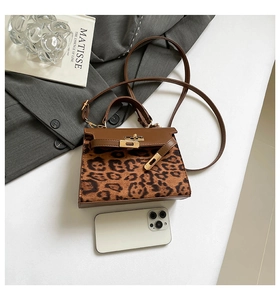 Detail of vintage leopard print handbag with leather panels and metal turn-lock closure