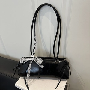 Black glossy patent leather baguette bag with white lace bow and dual slim straps