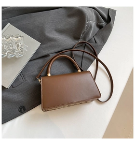 Detail of vintage crossbody bag with dark brown leather and monogram pattern patchwork